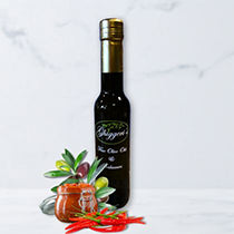 Bottle of red chili pepper olive oil with fresh cayenne peppers on light background