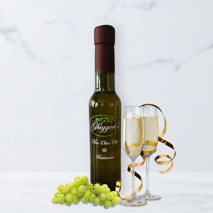 Champagne white balsamic vinegar bottle with golden bubbles, grapes, and a champagne flute

