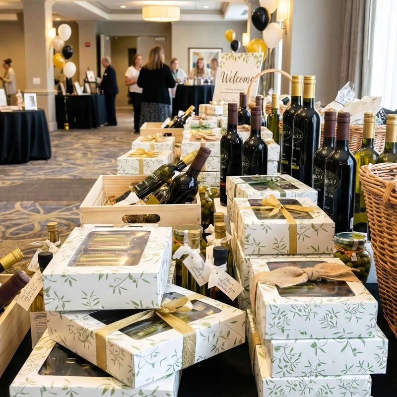 Display tables filled with boxed olive oil gift sets ready for guests at a corporate event.