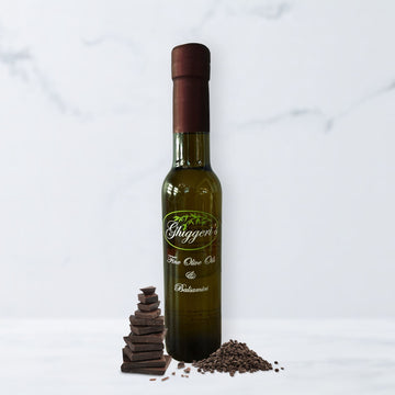 Dark chocolate balsamic vinegar bottle with rich chocolate squares and cocoa powder

