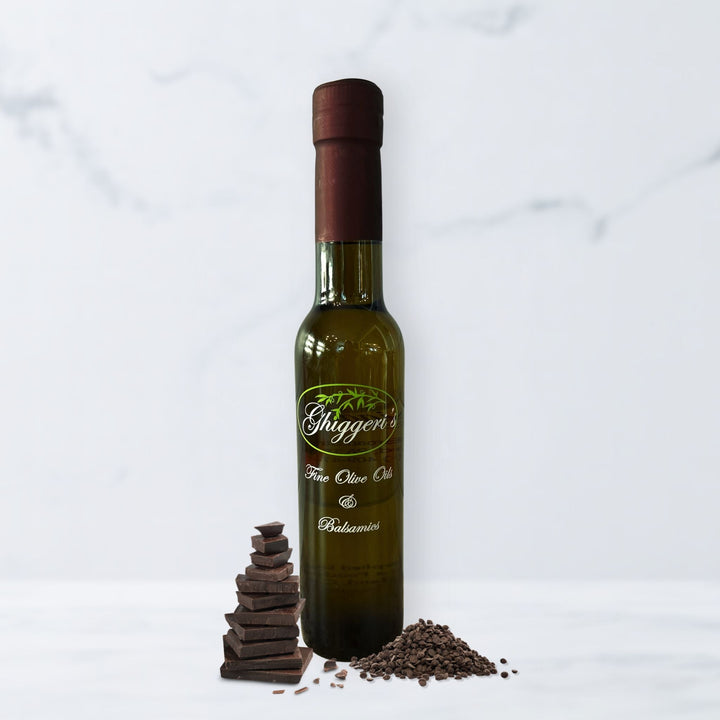 Dark chocolate balsamic vinegar bottle with rich chocolate squares and cocoa powder

