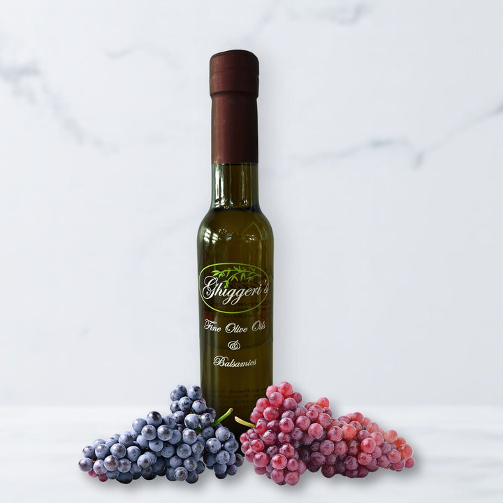 Aged Denissimo balsamic vinegar bottle with rich, thick pour and rustic wood barrel background

