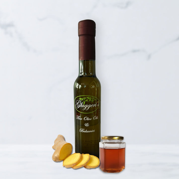 Honey ginger white balsamic vinegar bottle with honey dipper and fresh ginger