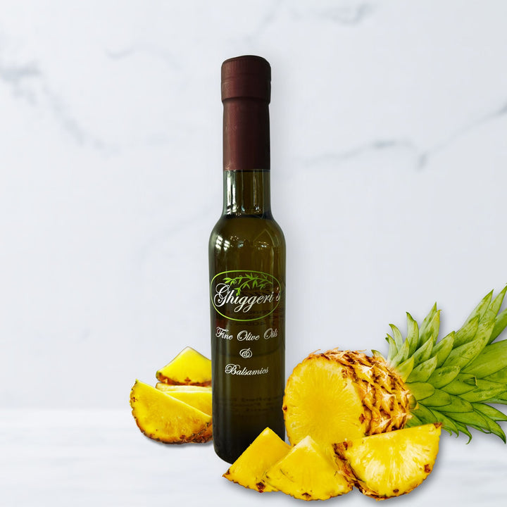Golden pineapple white balsamic vinegar bottle with sliced fresh pineapple